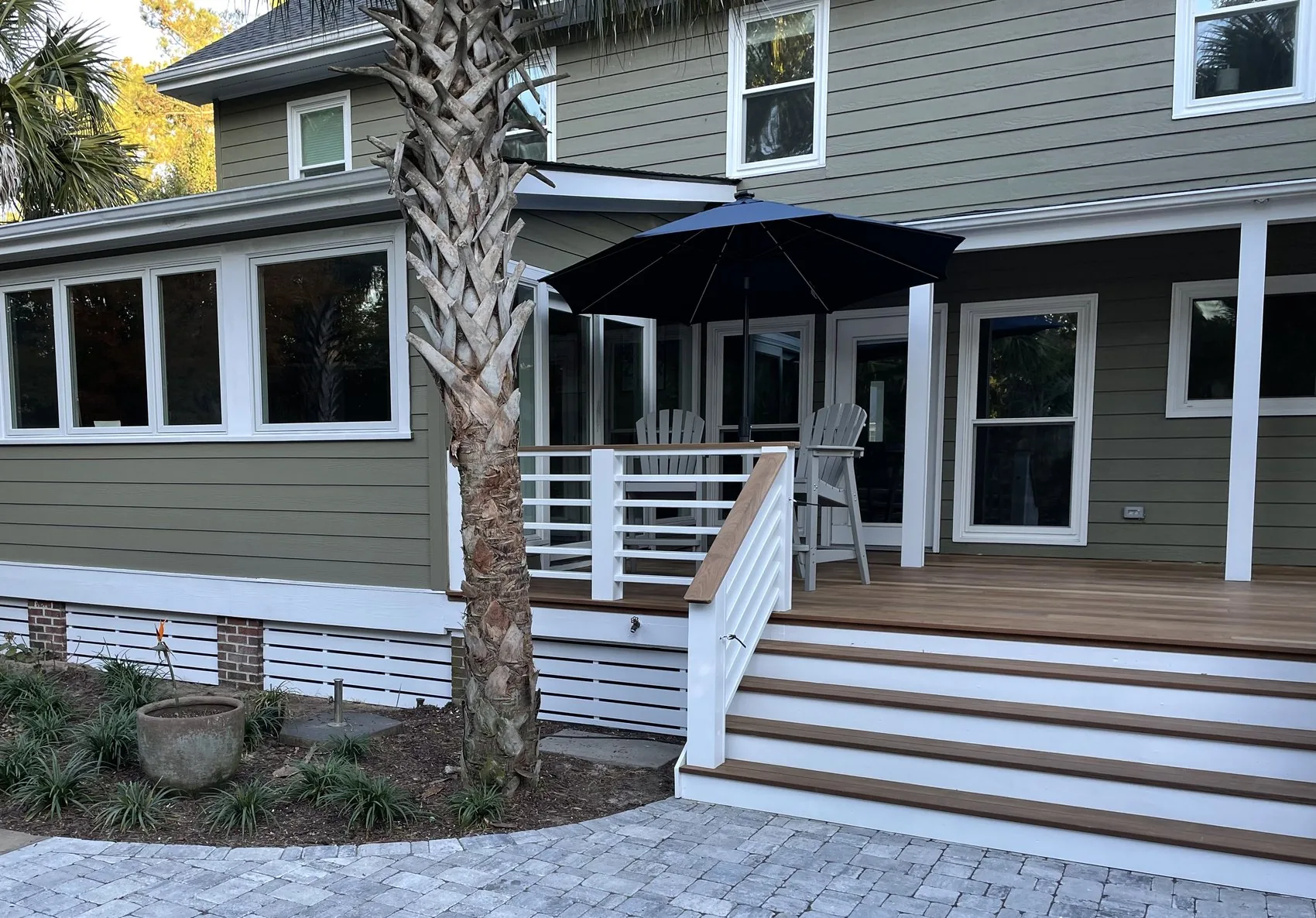 A coastal home by Avocet Design Build with a screened porch, paver walkway and new landscaping